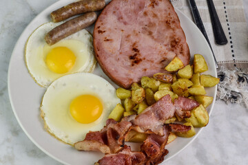 fried eggs  with ham, bacon and sausage