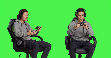Over greenscreen, asian teenager enjoys mobile video games holding smartphone and participating in...