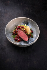 Traditionell gebratener Rehrücken mit Südtiroler mit Spätzle, Gemüse und Obst in Schokoladen Rotwein Sauce serviert als Nahaufnahme auf einem Nordic Design Teller mit Textfreiraum