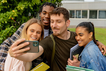 Fototapeta premium multiracial group of young college or high school students taking a selfie picture with a smartphone after class.