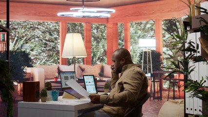 Business administrator discussing with the investors on phone call, communicating the sales numbers...