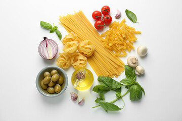 Different types of pasta, spices and products on white background, top view