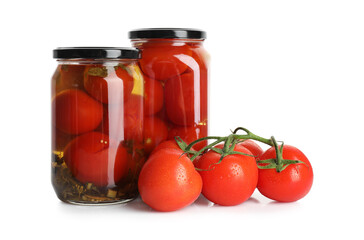 Tasty pickled tomatoes in jars and vegetable isolated on white