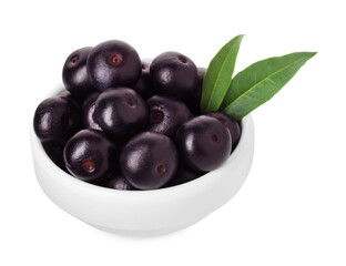 Fresh ripe acai berries in bowl and green leaves isolated on white