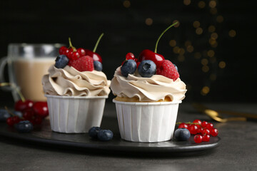 Tasty cupcakes with different berries on grey table, closeup