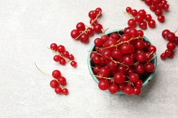 Fresh red currant in bowl on light table, top view