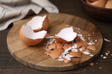 Pieces of broken eggshells on wooden table, closeup