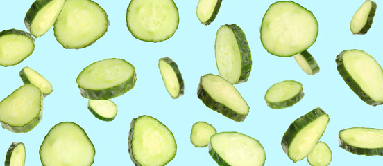 Fresh cucumber slices in air on light blue background. Banner design
