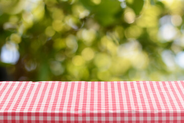 Red checkered tablecloth for picnic on table outdoors