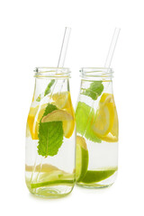 Bottles of tasty lemonade with mint and lime on white background