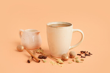 Cup of tasty masala tea with different spices on beige background