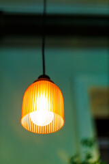 Orange pendant light hanging in a green room