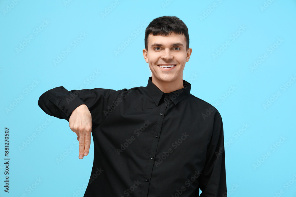 Wall mural Young deaf mute man using sign language on blue background