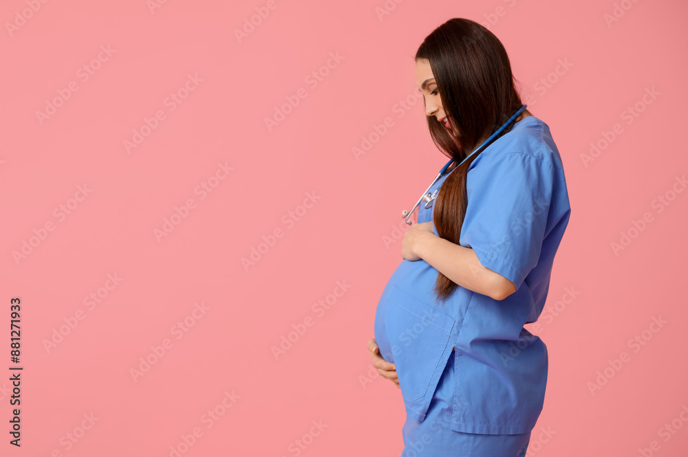 Wall mural Beautiful young pregnant doctor on pink background