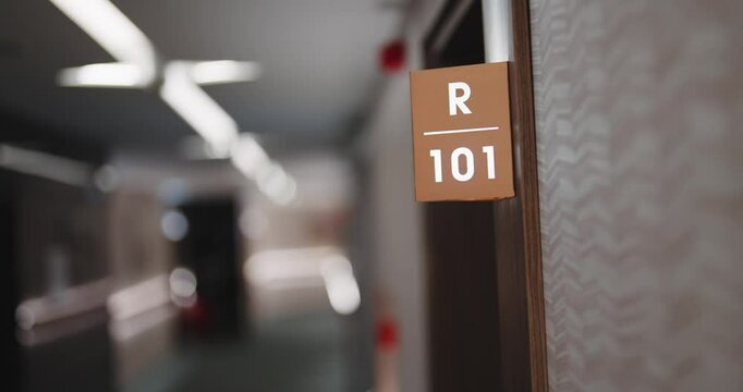 Luxury hotel empty hallway with sign of room number 101, establishing shot