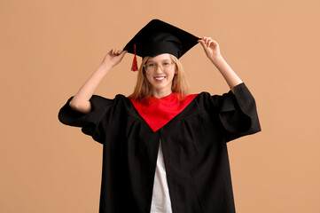 Female graduating student in mortar board on brown background
