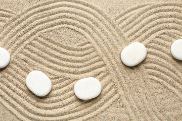 White spa stones on sand background