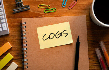 There is sticky note with the word COGS. It is an abbreviation for Cost of goods sold as eye-catching image.