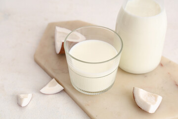 Stone tray, glass and bottle with tasty coconut milk on white background, closeup