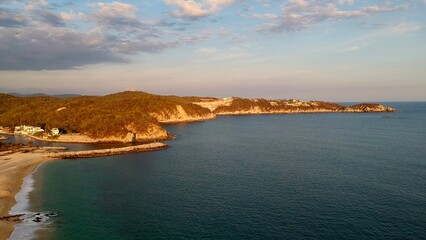 Beach and a hill in the background at sunset