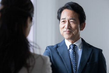 契約や商談などで握手するエグゼクティブなビジネスマンと営業