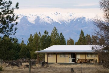 A cabin in the forest with snowy mountain in the background