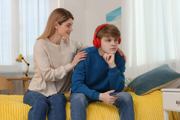 Mother comforting her upset teenage son at home