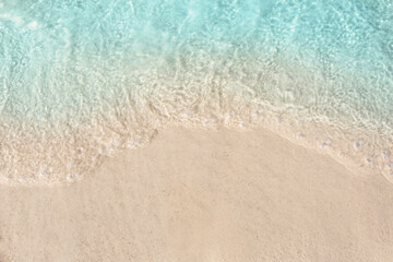 Sea waves rolling on beautiful sandy beach, top view. Summer vacation