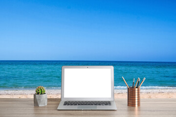 Workplace at beach, distant office. Table with laptop on sandy seashore. Mockup for design