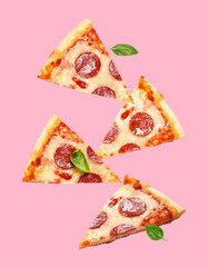 Pizza slices in air on pink background