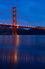 The Golden Gate Bridge reflected in the San Francisco Bay at dawn.