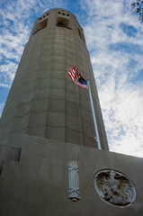 American flag waves against the Coit Tower in San Francisco, CA.