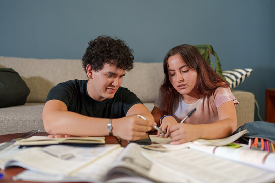 Pareja de chicos estudiando juntos en casa