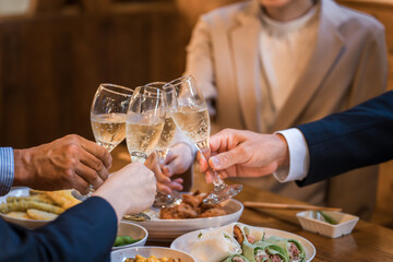 居酒屋で忘年会・新年会・飲み会・宴会をする仕事仲間・同僚・上司部下の男女
