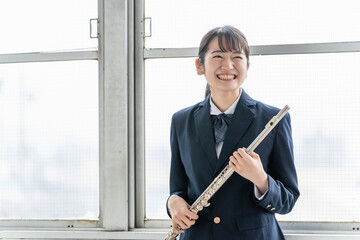 学校の部活動でフルートを練習するアジア人の女子高生  © buritora