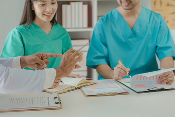 A group of practicing doctors in a meeting discusses patient diagnosis for health care. Create a plan or strategy together at the hospital or office. A group of medical personnel working as a team.