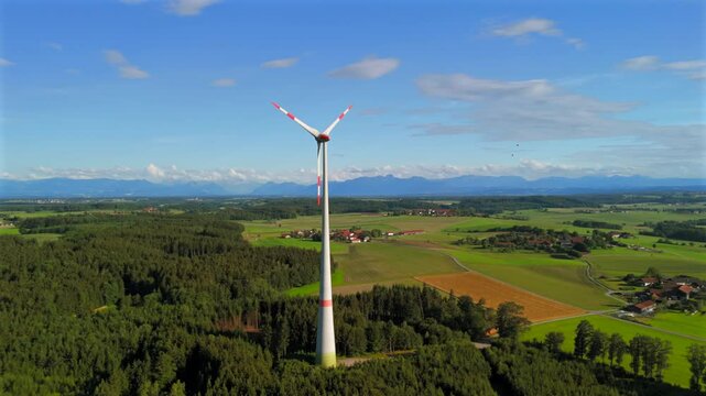 Aerial view of wind turbine in Bavaria, Ebersberg region, Germany. Luftaufnahme einer Windturbine vor dem Hintergrund der Alpen in Bayern, Deutschland. Wind turbine on golf course overlooking alps. 