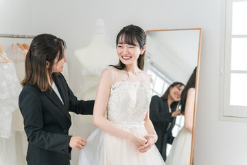 結婚式の準備でウェディングドレスの衣装合わせをするアジア人女性（試着・フィッティング）
