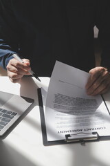 Asian businessman reviewing document reports at office workplace with computer laptop. legal...