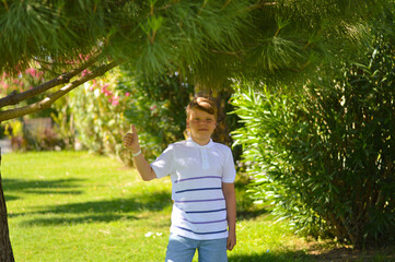 Close up of a young handsome positive curly boy with a smiling face wearing casual whit t-shirt...