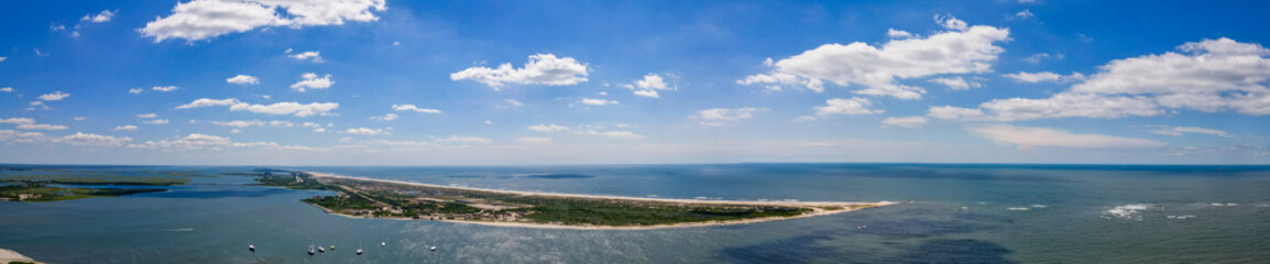 Panoramic view of Jones Beach with boats dotting the clear blue waters. Showcases the harmonious blend of marine activity and serene beach landscapes.