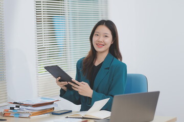 Asian professional businesswoman working on tablet computer in a corporate office