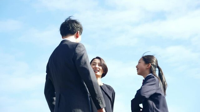 青空の下で会話する親子