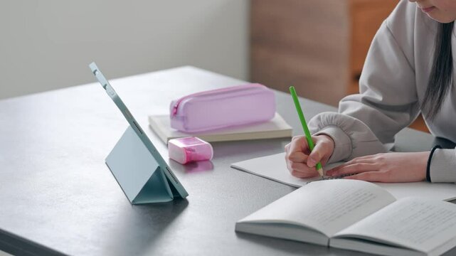 タブレットを見ながら勉強する女の子