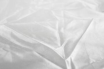 Fototapeta premium White crumpled satin fabric, abstract background close up texture