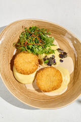 Gourmet Potato Puree with Fish Cutlets and Bisque Sauce Garnished with Mixed Greens