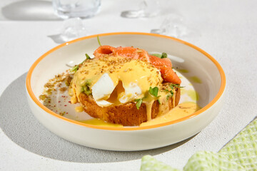 Gourmet Brioche with Poached Egg, Smoked Salmon, and Hollandaise Sauce - Elegant Breakfast Dish on Plate