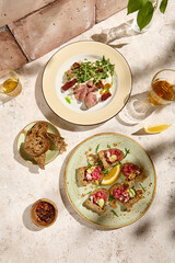 Authentic Still Life Roast Beef and Tuna Tartare on Natural Beige Table in Sunlit Setting
