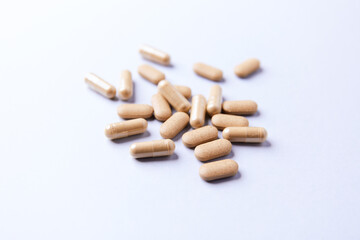 Ashwagandha (Withania somnifera) tablets and capsules on paper background. Soft focus.. Close up. Copy space.	