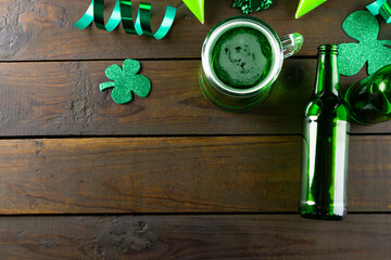 Image of beer glass, clover and copy space on wooden background © vectorfusionart